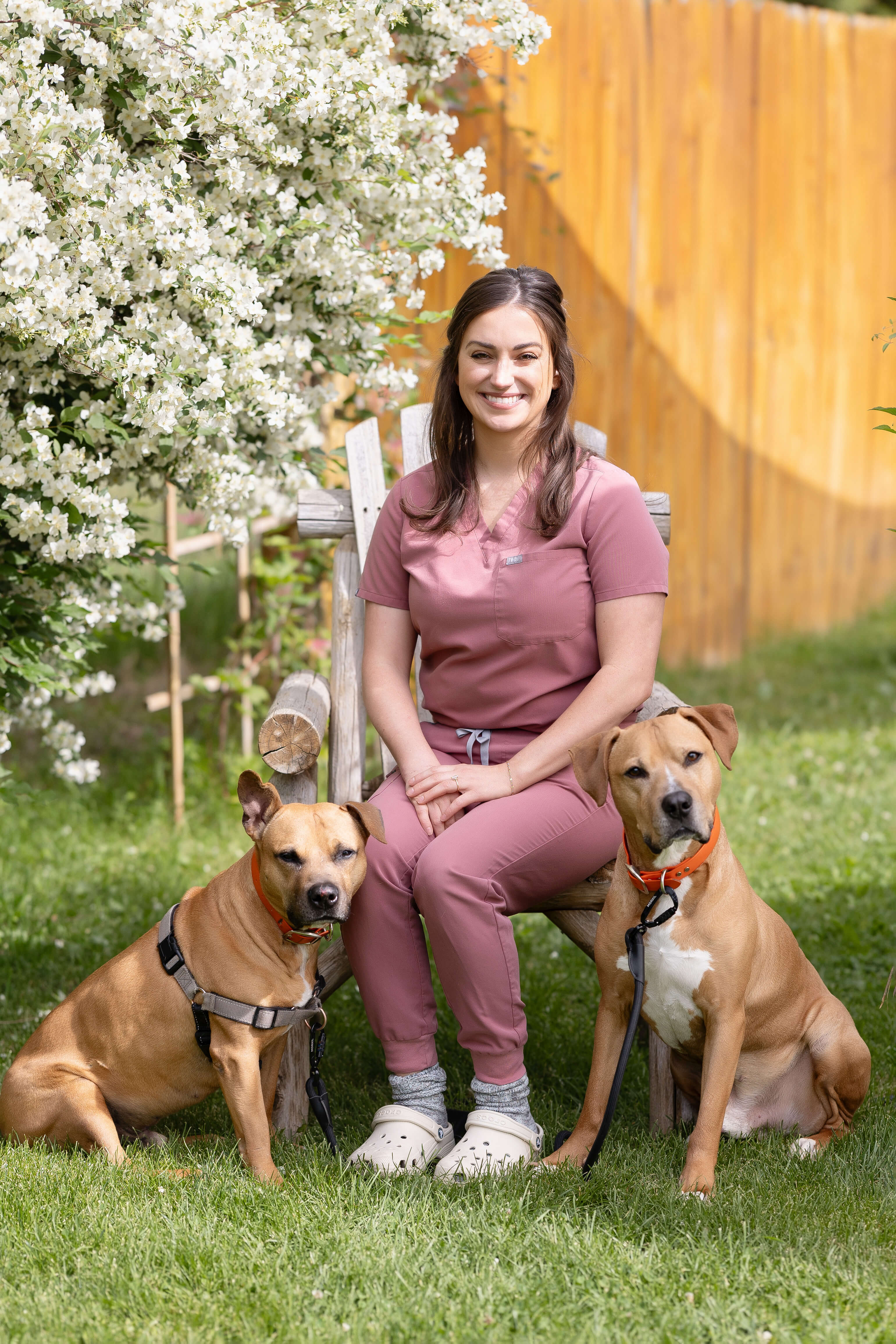 Female veterinarian sitting outside with her dogs